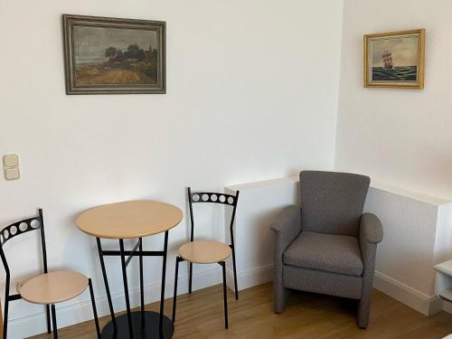 um quarto com duas cadeiras, uma mesa e uma cadeira em Villa Edda - Ferienzimmer 17 em Graal-Müritz