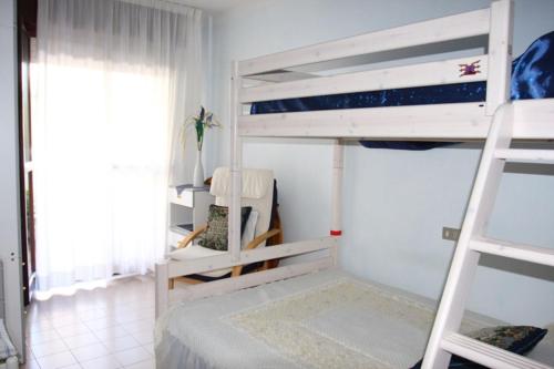 a bedroom with two bunk beds and a window at Nice Apartment only 150 metres from the Beach by Beahost Rentals in Bibione