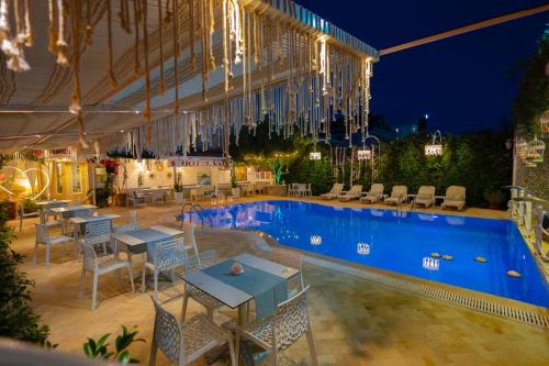 a swimming pool with tables and chairs next to a building at Hotel Valz in Velipojë