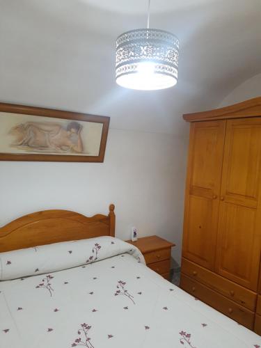 a bedroom with a bed and a chandelier at Cueva Maite in Cortes de Baza