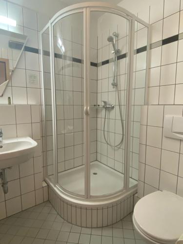 um chuveiro na casa de banho com um WC e um lavatório em Villa Edda - Ferienzimmer 17 em Graal-Müritz