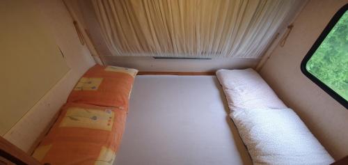 Habitación pequeña con 2 camas y ventana en AUTO KAMP DRINA, en Crnča