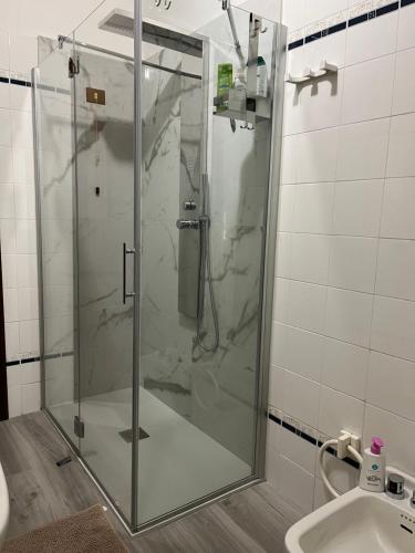 uma cabina de duche em vidro na casa de banho com um lavatório em Home Azzurra em Capolona