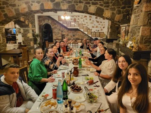 a group of people sitting at a table eating food at N’Kanu in Rrëshen