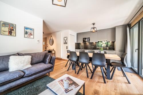un salon avec un canapé et une table dans l'établissement Elouera Les Gets - BY EMERALD STAY, aux Gets