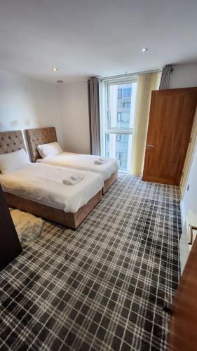 een hotelkamer met 2 bedden en een raam bij Luxury 2 Bed Apartment EXCEL London in Londen