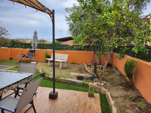 a patio with a table and chairs and a tree at Domus Mariposa in Tortolì
