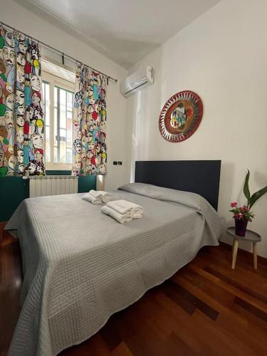 - une chambre avec un lit et des serviettes dans l'établissement Casa Elle, à Catane