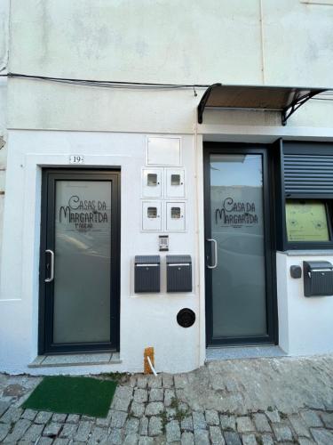 a white building with two doors on the side of it at Casas da Margarida in Vila Nova de Foz Coa