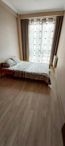 a bedroom with a bed in front of a window at Balavari Samgori Guest House in Tbilisi City