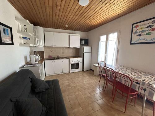 une cuisine avec une table et des chaises dans une pièce dans l'établissement Maison cosy 2 pièces, plage et centre à 300m, terrasse, TV, animaux permis - La Guérinière - FR-1-224B-192, à La Guérinière