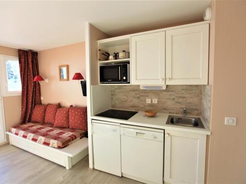 - une cuisine avec des placards blancs, un évier et un canapé dans l'établissement Appartement 5 personnes au pied des pistes avec balcon et Wifi - FR-1-314-172, à Avoriaz