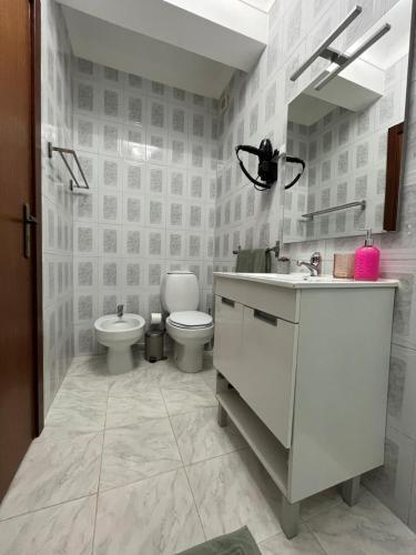 ein weißes Bad mit einem WC und einem Waschbecken in der Unterkunft Casas da Margarida in Vila Nova de Foz Côa