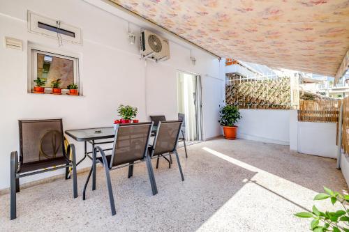 un patio con tavolo e sedie in un edificio di Koukaki Apartment ad Atene