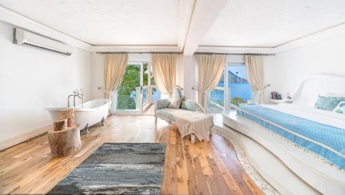 a bedroom with a large bed and a tub and a bath tub at Likya Gardens Hotel in Kas