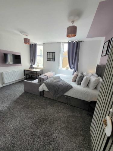 1 dormitorio con 1 cama grande y TV en Blackpool Abode - Sunny Suite Apartment, en Blackpool