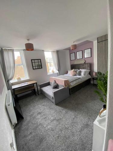 1 dormitorio grande con 1 cama y 1 sofá en Blackpool Abode - Sunny Suite Apartment, en Blackpool