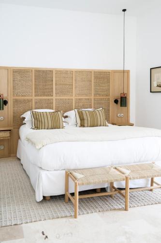 two large beds in a room with a bench at Le Couvent des Minimes, un Hôtel & Spa L'Occitane en Provence in Mane