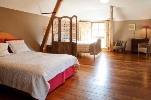 a bedroom with a bed and a desk and a chair at Ferme de l'Abbaye St-Feuillien in Roeulx