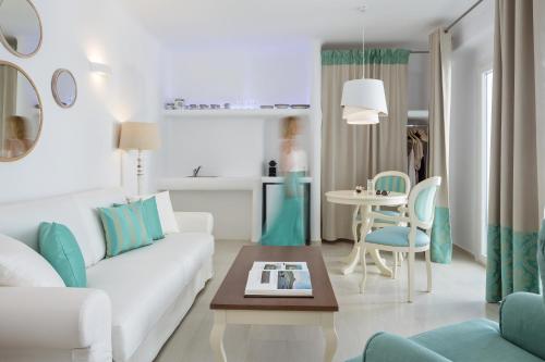 a living room with a white couch and a table at Colours of Mykonos Luxury Residences & Suites in Psarou