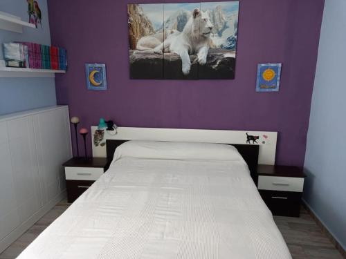 1 dormitorio con cama blanca y pared morada en Vacaciones en Marbella, en Marbella