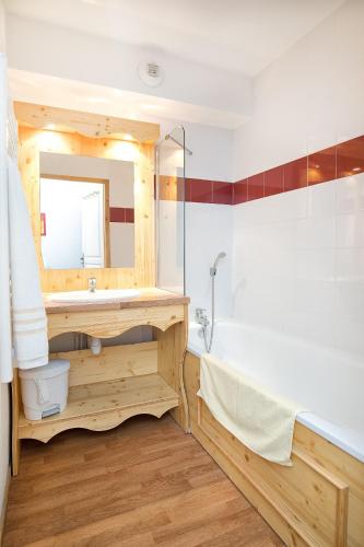une salle de bain avec un lavabo, une baignoire et un miroir dans l'établissement Hameau 8 102 - SPA & PISCINE appartement 4 pers, à Orelle