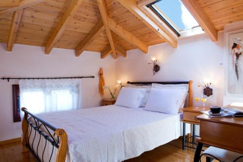 a bedroom with a large bed and a wooden ceiling at Aelia Villa in Sivota
