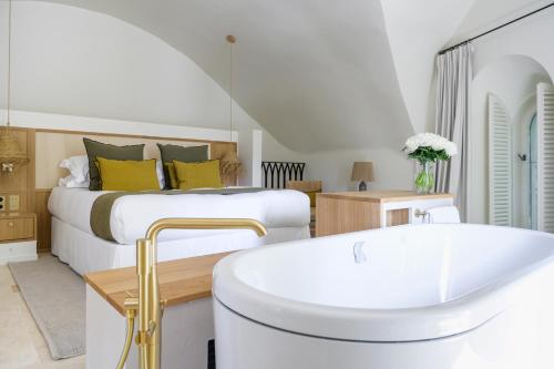 a bedroom with a bed and a bath tub at Le Couvent des Minimes, un Hôtel & Spa L'Occitane en Provence in Mane