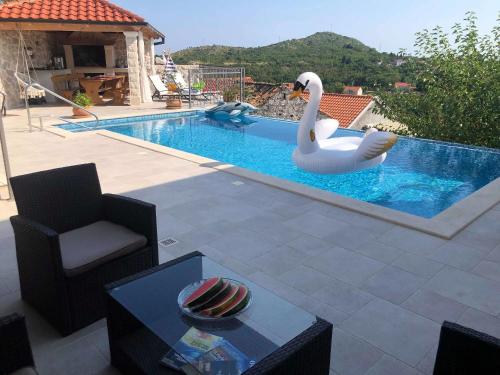 - une piscine avec un cygne dans l'eau dans l'établissement House Marija, à Orašac