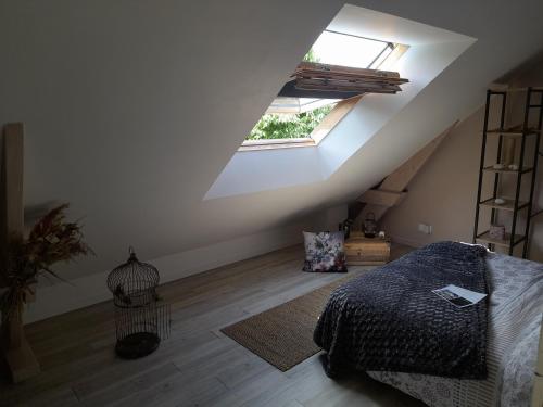 Cette chambre mansardée comprend un lit et une fenêtre. dans l'établissement CHAMBRE CHAMPÊTRE, à Angrie