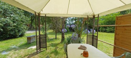 a patio with a table and an umbrella at la Sapinière in Saint-Vincent-de-Paul