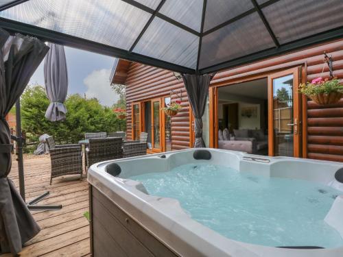 a hot tub on the deck of a house at Little Lodge in Kings Lynn