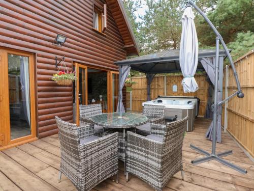 a patio with a table and an umbrella at Little Lodge in Kings Lynn