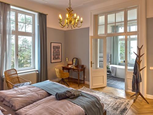1 dormitorio con cama, escritorio y baño en Pineblue Villas en Heringsdorf