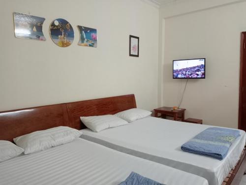 a bedroom with two beds and a tv on the wall at Quân Nguyễn in Vung Tau