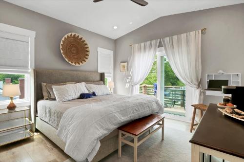 Schlafzimmer mit einem Bett, einem TV und Fenstern in der Unterkunft Whalers Paradise in Carolina Beach