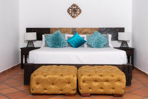 a bedroom with a large bed with blue pillows at Hotel Campestre Cafe Cafe in Montenegro