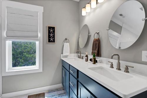 ein Badezimmer mit 2 Waschbecken und einem Spiegel in der Unterkunft Whalers Paradise in Carolina Beach