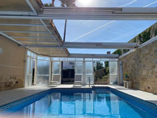 einen Pool in einem Haus mit Glaserweiterung in der Unterkunft Villa Benjamina avec piscine climatisée in Altea