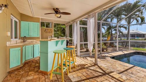 a kitchen with blue cabinets and a swimming pool at 829 Napoli in Punta Gorda