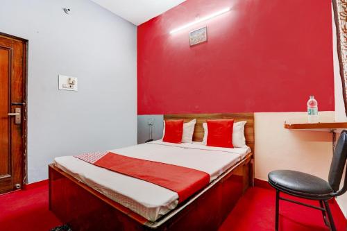 Camera rossa con letto e sedia di OYO Hotel Fridays a Bathinda