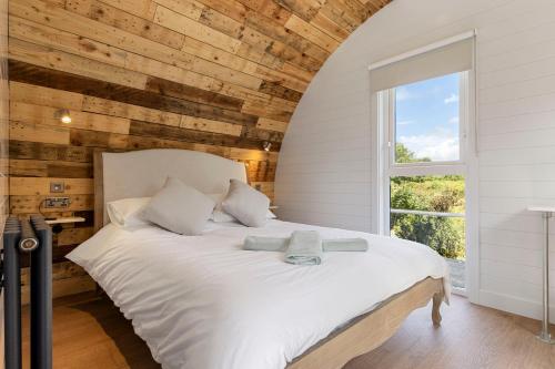 a bedroom with a white bed with a window at Choller Lake Lodges - The Lake House With Private Hot Tub in Arundel
