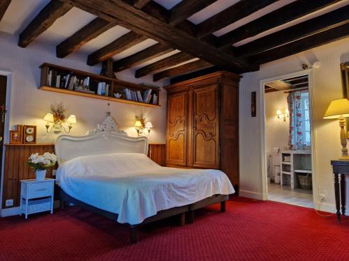 クル・シュヴェルニにあるLa Bervinièreの白いベッドと木製の天井が備わるベッドルーム1室が備わります。