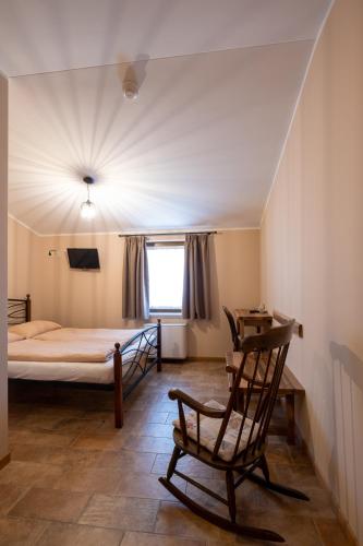 a bedroom with a bed and a rocking chair at Farm Stay Malovščevo in Vitovlje