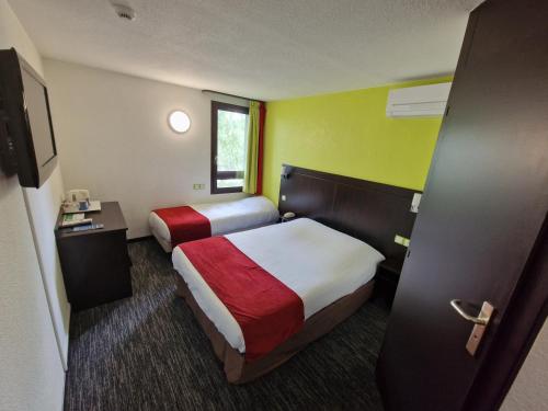 a hotel room with two beds and a television at Kyriad Montluçon - Saint Victor in Saint-Victor