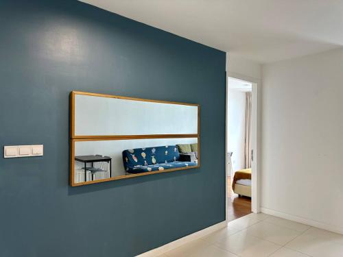 a living room with a blue wall with a mirror at Luxury Condo Jalan Tun Razak in Kuala Lumpur