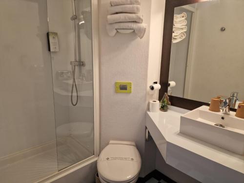 e bagno con doccia, servizi igienici e lavandino. di Kyriad Montluçon - Saint Victor a Saint-Victor