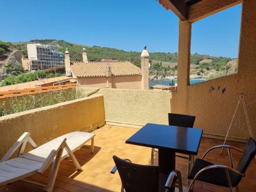 un patio avec une table et des chaises sur un balcon dans l'établissement Studio accès direct à la plage, à Banyuls-sur-Mer