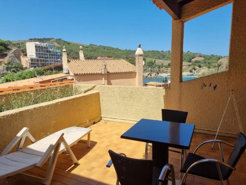 eine Terrasse mit einem Tisch und Stühlen auf dem Balkon in der Unterkunft Studio accès direct à la plage in Banyuls-sur-Mer