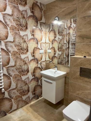 a bathroom with a toilet and a stone wall at Spalskie Pokoje Gościnne in Spała